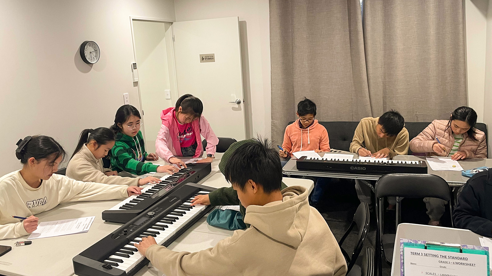 Students learning music theory and keyboard skills together in a structured Dorayme class