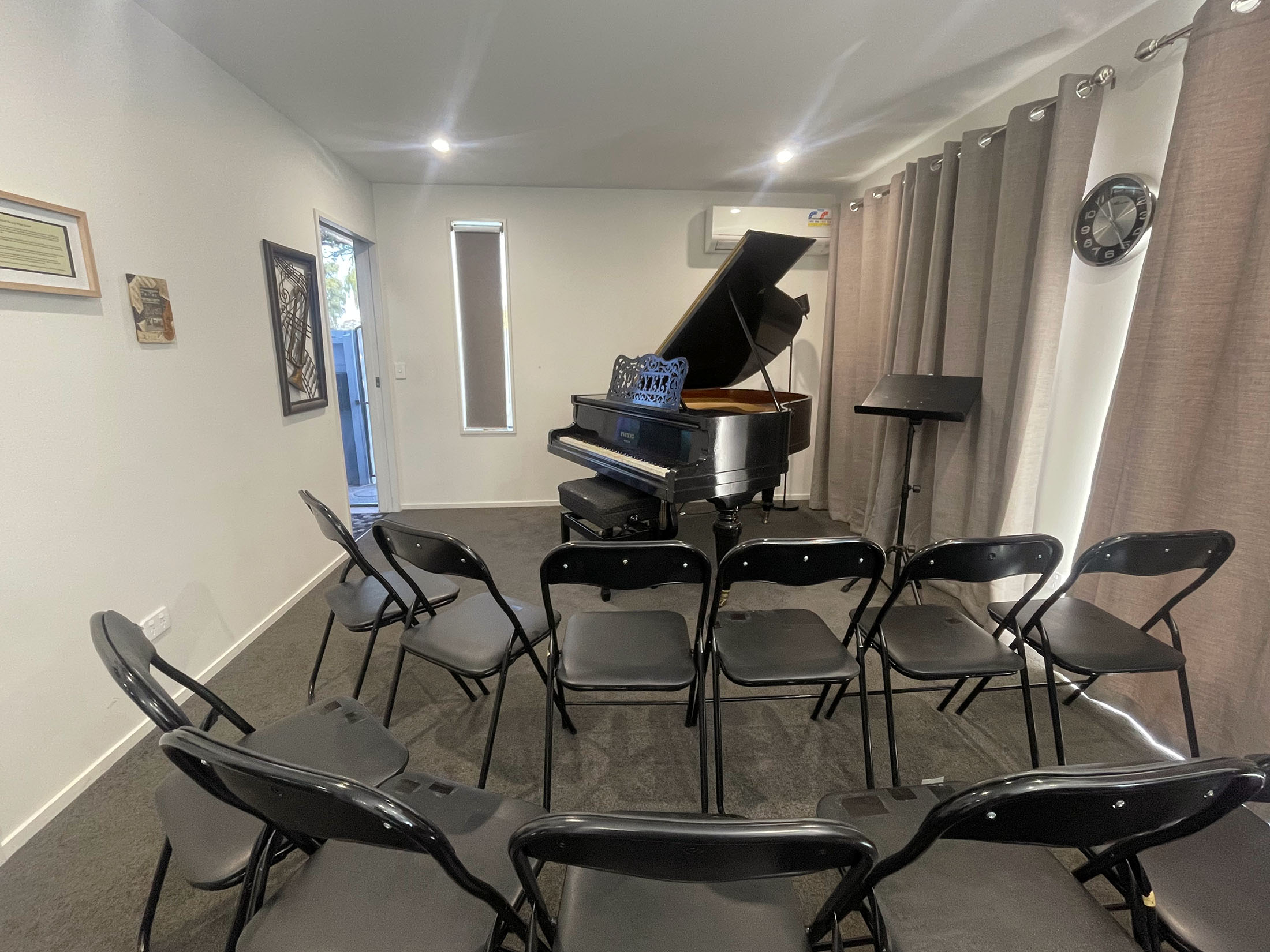 Intimate recital room with grand piano and audience seating